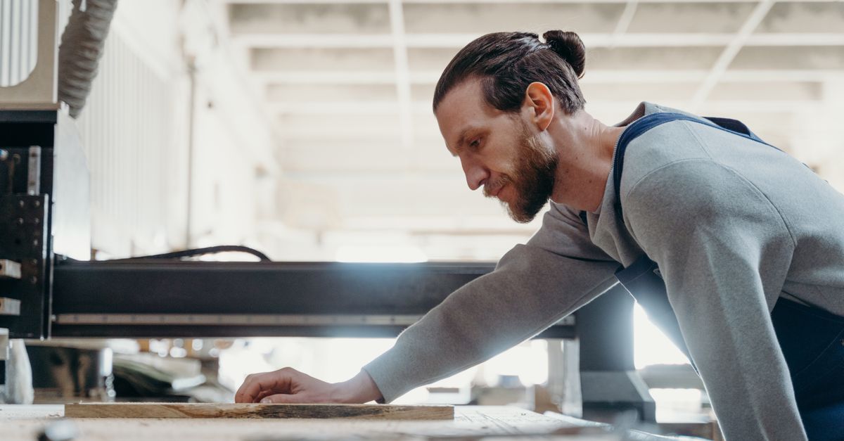 Artisan working at a woodworking machine in a well-lit studio