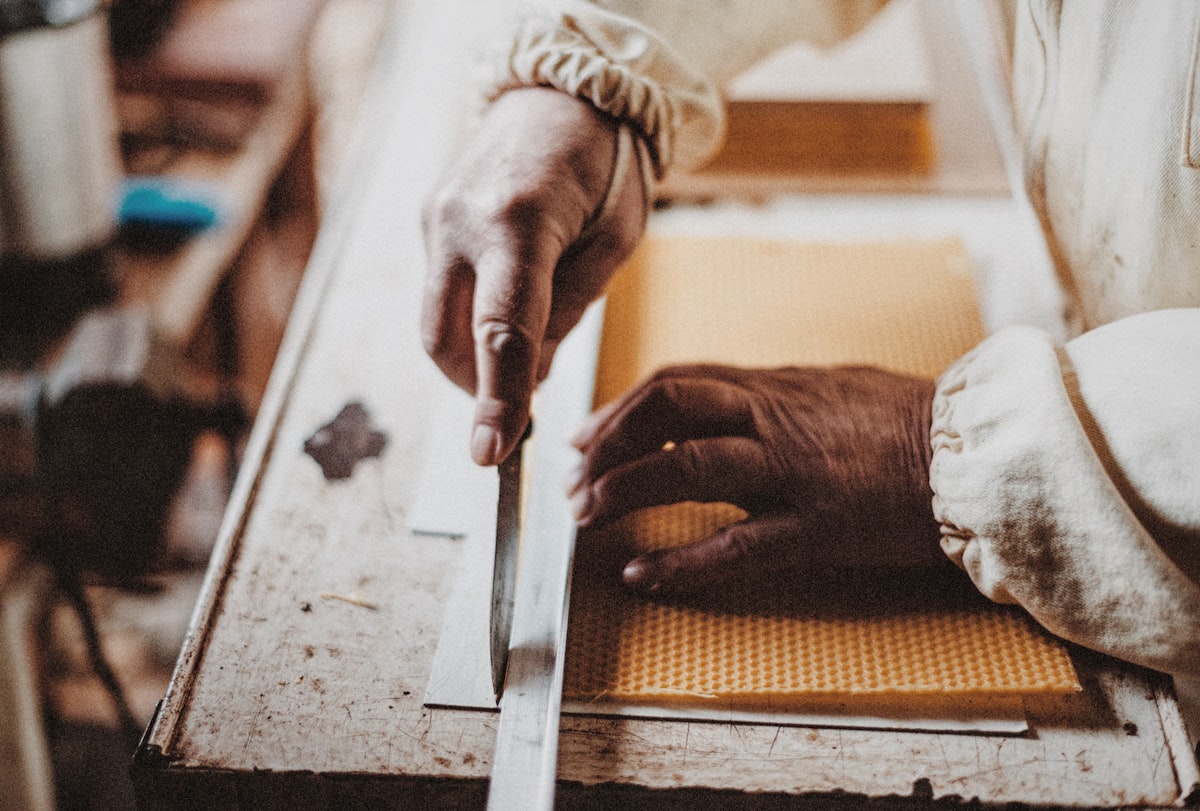 Hands carving wood with a chisel in a workshop
